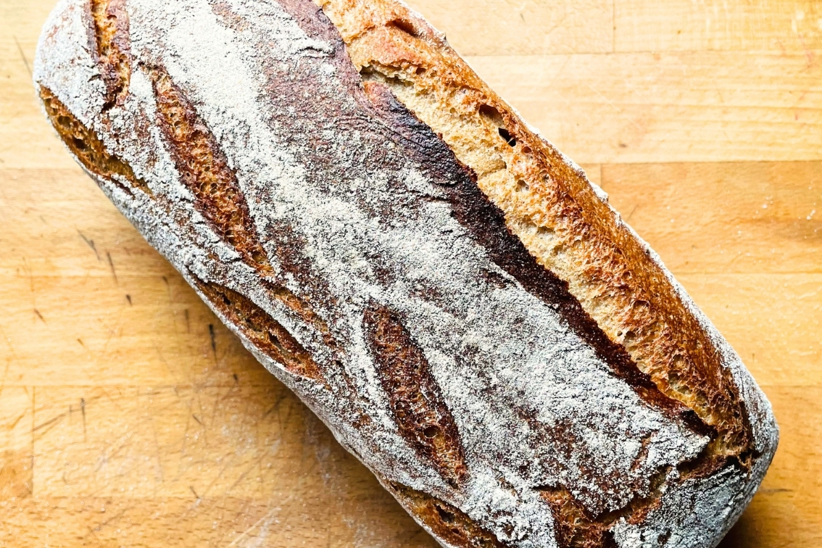 Frisch gebackenes Sauerteigbrot in Kastenform auf Holzbrett