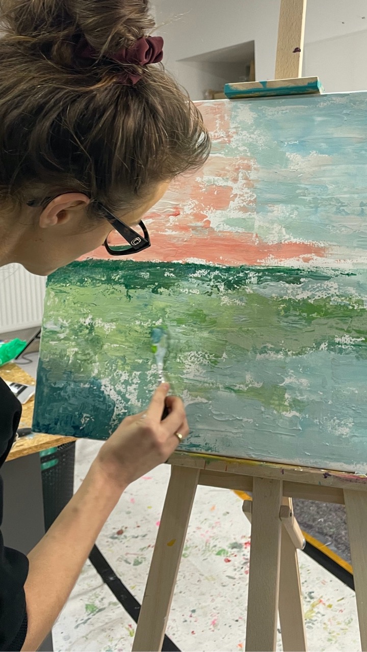 Teilnehmerin arbeitet konzentriert an einer abstrakten Leinwand während des Kopf-FREI-Art-Workshops im Atelier von LadyMARIANN-Arts.