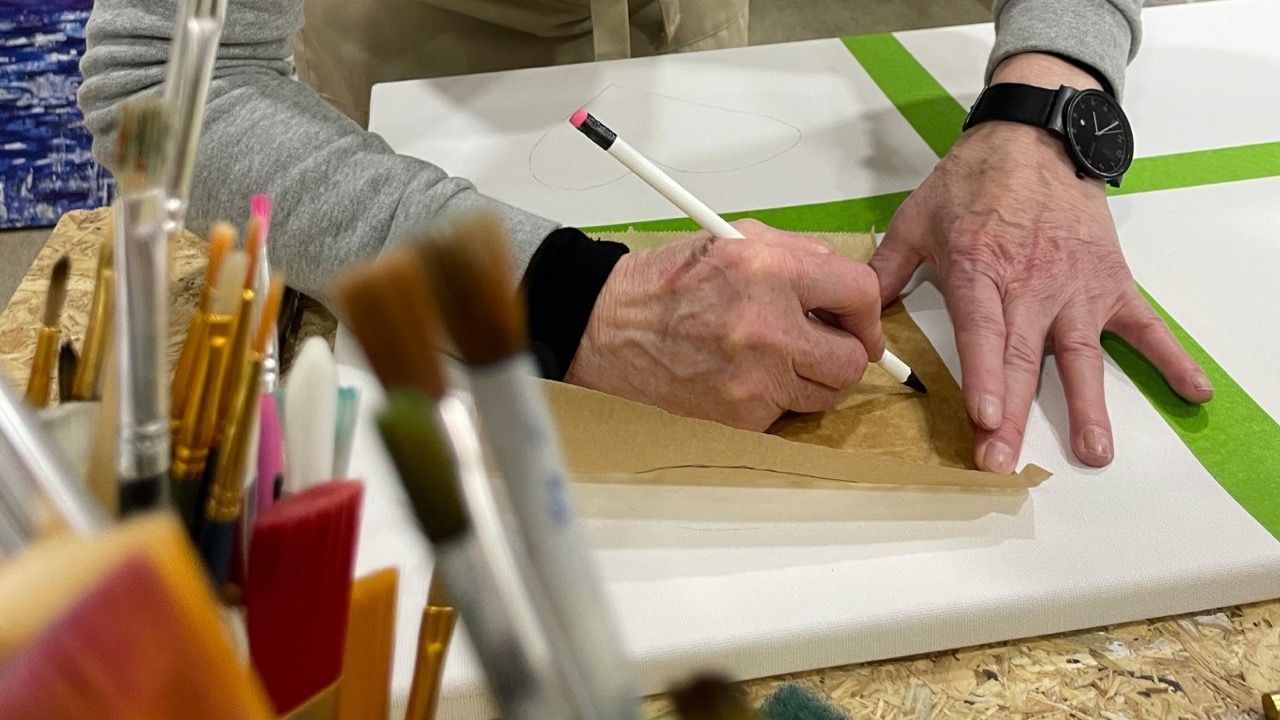 Detail Hände einer Teilnehmerin bei der konzentrierten Arbeit an einer abstrakten Leinwand während des Kopf-FREI-Art-Workshops im Atelier von LadyMARIANN-Arts.