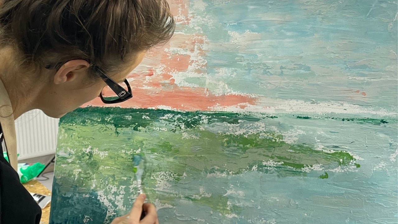 Teilnehmerin arbeitet konzentriert an einer abstrakten Leinwand während des Kopf-FREI-Art-Workshops im Atelier von LadyMARIANN-Arts.